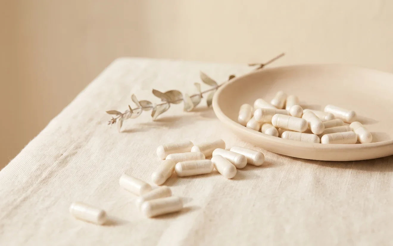 Probiotic capsules in a pale ceramic dish on cream linen
